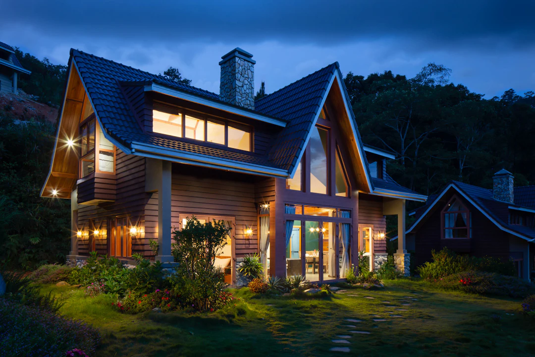 Chalet contemporain en bois aux fenêtres illuminées à l’heure bleue